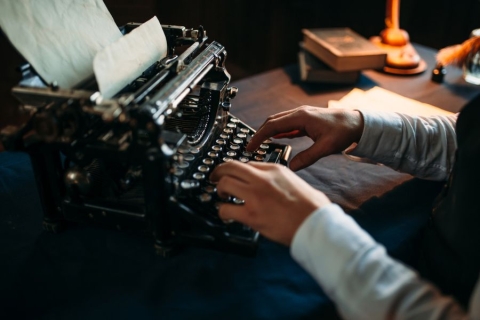 man typing on typewriter